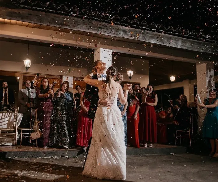 Primer baile de los novios con los invitados lanzando pétalos